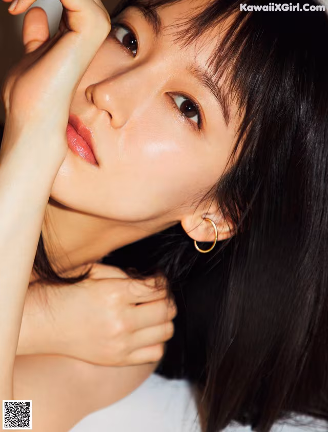 A woman with long black hair is posing for a magazine.