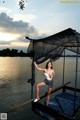 A woman standing on a dock holding a fishing net.