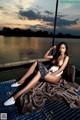 A woman sitting on top of a boat on a lake.