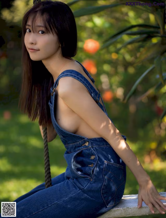 A woman sitting on a swing in a park.