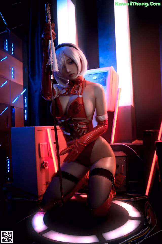 A woman in a red and black outfit holding a sword.