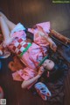 A woman in a pink kimono laying on the floor.