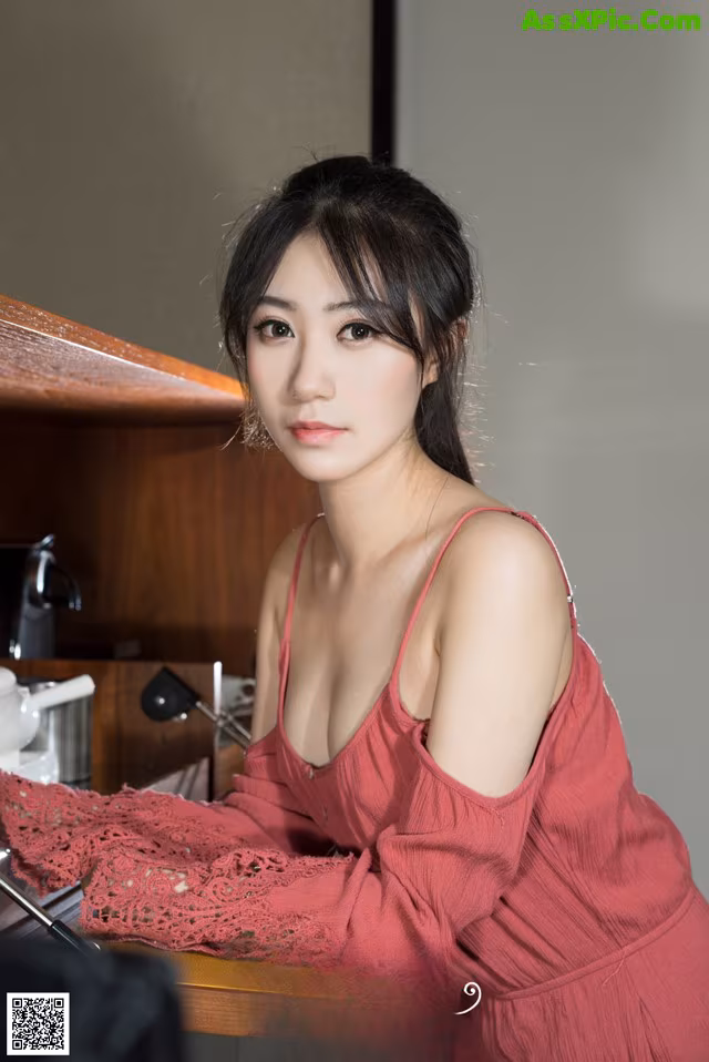 A woman in a red dress sitting at a table.