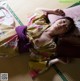 A woman in a kimono laying on a bed.