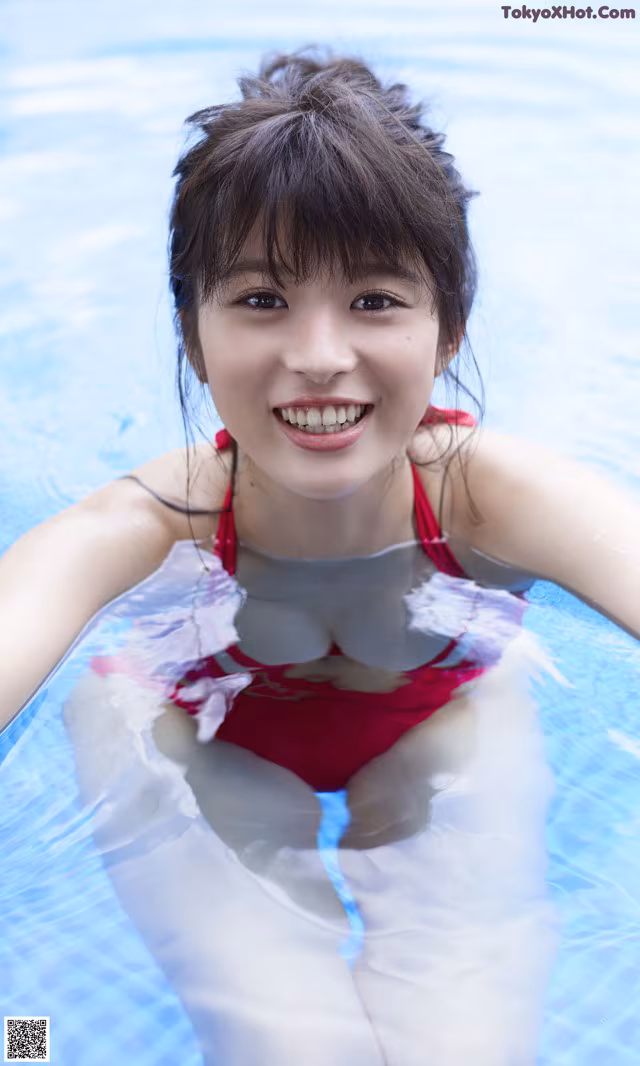 A woman in a red bathing suit in a swimming pool.