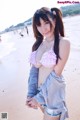 A woman in a pink bikini standing on a beach.